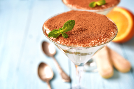 Italian dessert tiramisu with orange in a glass on a blue background.の写真素材