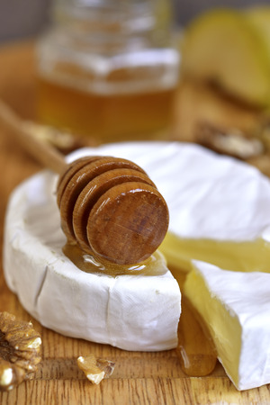 Camembert with honey,walnuts and pear on an old wooden background.の写真素材