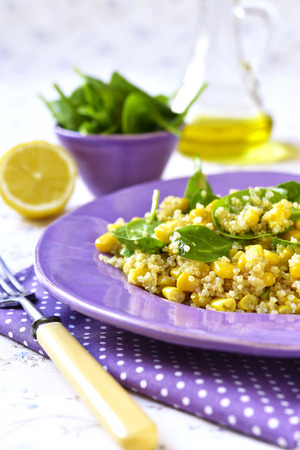 Quinoa salad with spinach and sweet corn on a purple plate.Vintage style.の写真素材