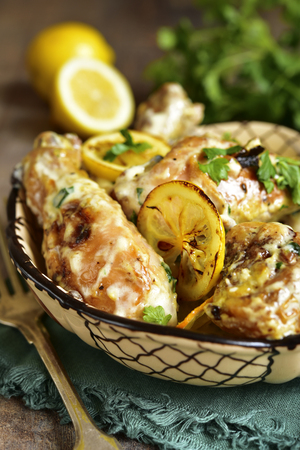 Chicken legs stewew in a cream lemon sauce on a rustic wooden background.の写真素材