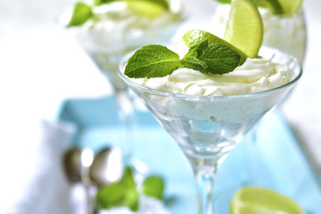 Lime and mint cheesecake in a glass on a blue wooden tray.の写真素材