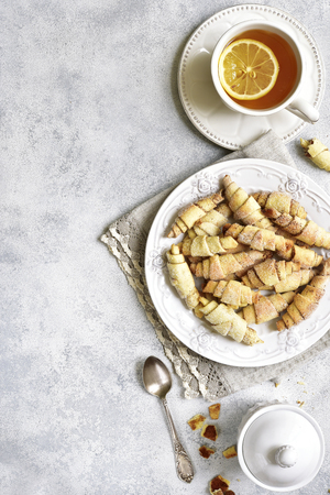 Cinnamon cookies and cup of tea for a breakfast on a white vintage plate on a slate,stone or concrete background.Top view.の写真素材