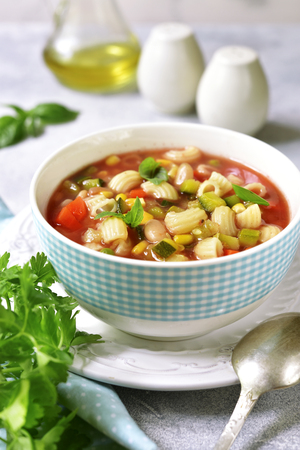 Minestrone - traditional italian vegetavle soup in a bowl on a light slate,stone or concrete background.の写真素材