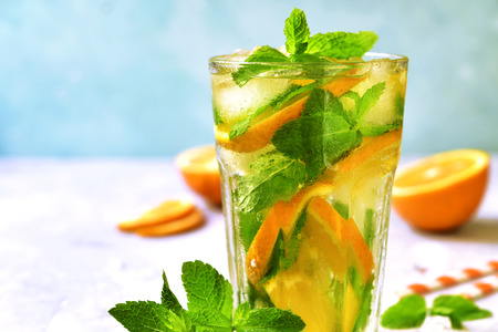 Homemade orange lemonade in a tall glass on a slate,stone or concrete background.の写真素材