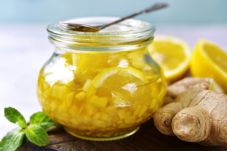 Vitamin mix for making a warming tea : ginger,lemon,honey and cinnamon in a vintage glass jar.の写真素材