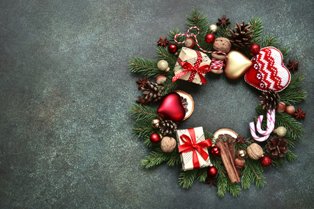 Christmas wreath made from vintage christmas toys and festive decorations over fir branches on a green slate,stone or concrete background.Top view copy space.の写真素材