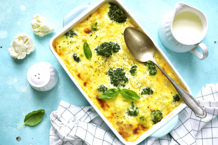 Cauliflower broccoli gratin in a baking dish on a light blue slate,stone or concrete background.Top view.の写真素材