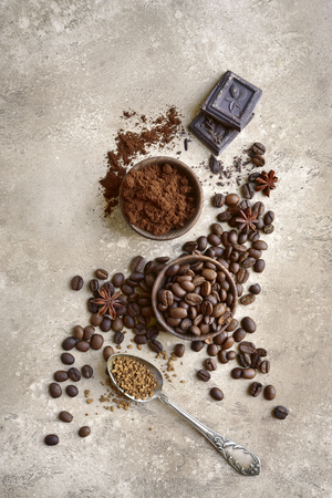 Ground coffee and coffee beans with spices over beige rustic slate, stone or concrete background.Top view.の写真素材