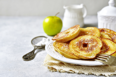Apple pancakes for a breakfast on white plate over light slate, stone or concrete background.の写真素材