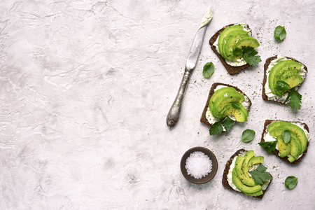 Rye avocado toasts with ricotta cheese. Top view with copy space.の写真素材