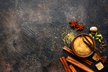 Assortment of winter spices : cinnamon, anise, cardamon, nutmeg, clove, vanilla and brown sugar on a dark slate, stone, concrete or metal background.Top view with copy space.の写真素材