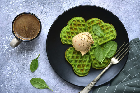 Spinach avocado waffles with cream cheese ball on a black plate over light grey slate, stone or concrete background.Top view with copy space.の写真素材