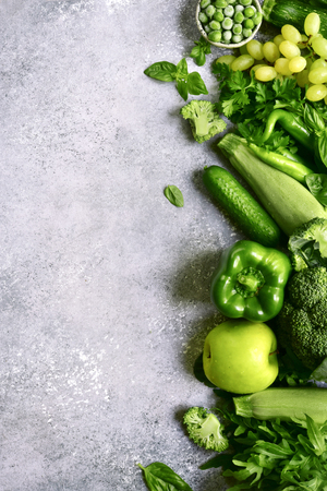 Variety of fresh green fruits and vegetables on a light grey slate, stone or concrete background.Top view with copy space.の写真素材