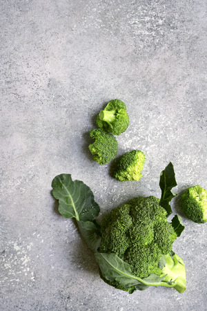 Raw fresh organic broccoli on a grey slate, stone or concrete background.Top view with copy space.の写真素材