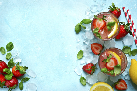 Homemade strawberry lemonade with basil in a glass over light blue slate, stone or concrete background. Top view with copy space.の写真素材