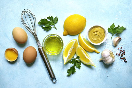 Ingredients for making homemade natural mayonnaise sauce on a light blue slate, stone or concrete background.Top view with copy space.の写真素材