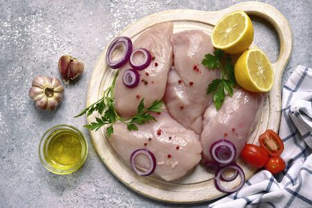 Raw organic chicken breast on a light grey slate, stone or concrete background.Top view with copy space.の写真素材