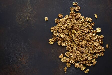 Heap of raw peelled organic walnuts on a dark slate, stone or concrete background. Top view with copy space.の写真素材
