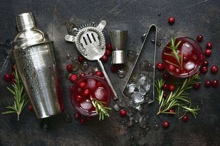 Winter christmas cocktail with cranberry and rosemary in a glasses on a dark slate, stone or concrete background. Top view with copy space.の写真素材