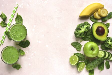 Green vegetable detox smoothie with ingredients for making in a glasses on a light pink slate, stone or concrete background. Top view with copy space.の写真素材