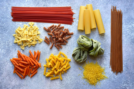 Variety of traditional italian pasta : colorful spaghetti, tagliatelle, farfalle, penne, noodle,...