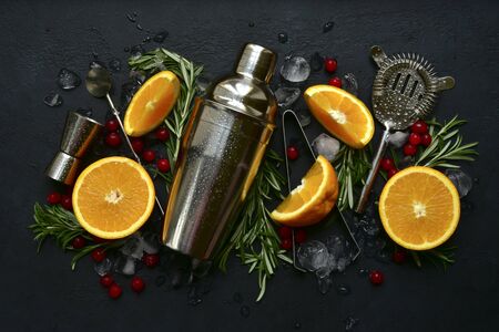 Ingredients and props for making festive christmas cocktail on a black slate, stone or concrete background. Top view with copy space.の写真素材