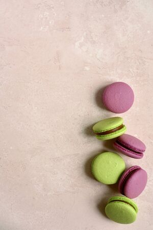 Homemade french almond cookies macarons on a light pink slate, stone or concrete background.Top view with copy space.の写真素材