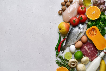 Food background with healthy clean organic ingredients of paleo menu on a grey slate, stone or...
