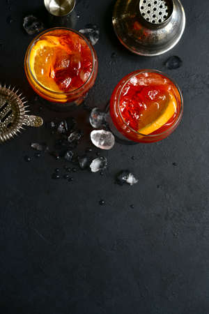 Delicious italian cocktail with orange in a glasses on a black slate, stone or concrete background. Top view with copy space.の写真素材