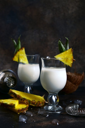 Pina colada - tropical pineapple coconut cocktail with white rum and cream in a glasses on a darl...