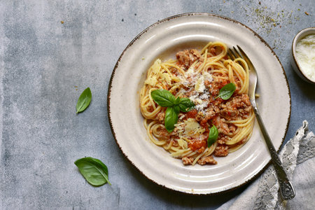 Traditional italian dish spaghetti bolognese - pasta with minced meat and tomatoes on a plate over...