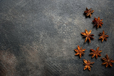 Food background with anise stars on a dark table. Top view with copy space.