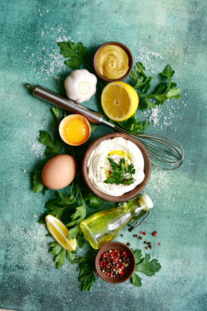 Fresh ingredients for making mayonnaise sauce on green slate, stone or concrete background. Top view with copy space.の写真素材