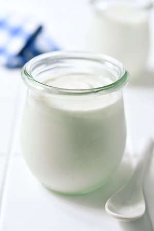 Natural organic yogurt in a vintage glass jar on a white slate, stone or concrete background.の写真素材