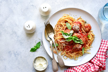 Pasta spaghetti with meat ball in tomato sauce on a plate over light gray slate, stone or concrete background. Top view with copy space.の写真素材