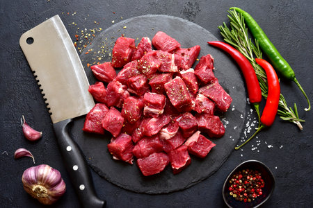 Raw organic meat ( beef or lamb ) on a black slate board. Top view with copy space.の写真素材