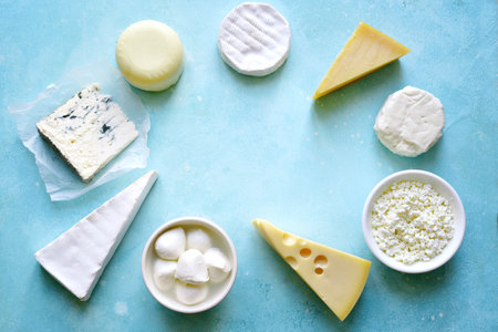 Food background with different types of cheese on a turquoise table. Top view with copy space.の写真素材
