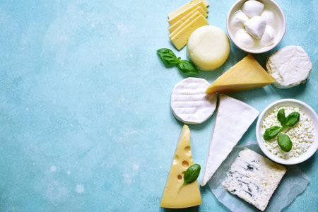 Food background with different types of cheese on a turquoise table. Top view with copy space.の写真素材