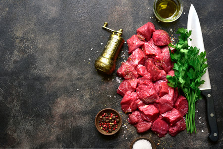 Raw organic meat ( beef or lamb ) on a dark slate, metal, stone or concrete background. Top view with copy space.の写真素材