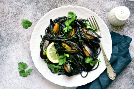 Black spaghetti pasta with mussels on a light gray slate, stone or concrete background. Top view with copy space.の写真素材