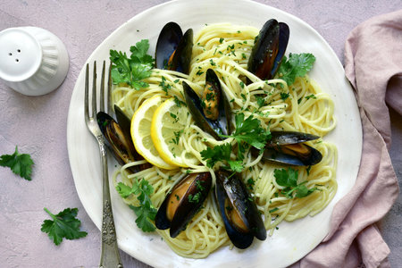Delicious spaghetti with clams in a cream sauce on a white plate over light slate, stone or concrete background.Top view with copy space.の写真素材