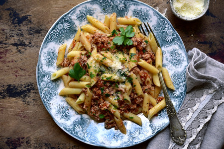 Traditional italian pasta bolognese on a plate over rustic wooden background. Top view with copy space.の写真素材
