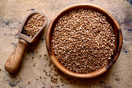 Raw organic buckwheat in a wooden bowl over rustic background. Top view with copy space.の写真素材