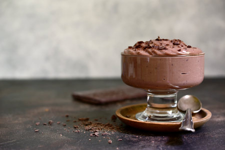 Homemade delicious chocolate pudding or mousse in a glass vase on a light slate, stone or concrete background.の写真素材