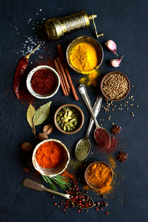 Assortment of natural organic spices on a black slate, stone or concrete background. Top view with copy space.の写真素材