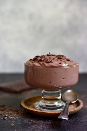 Homemade delicious chocolate pudding or mousse in a glass vase on a light slate, stone or concrete background.の写真素材