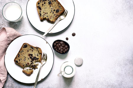 Homemade delicious cake with chocolate drops on a plates over white slate, stone or concrete background. Top view with copy space.の写真素材