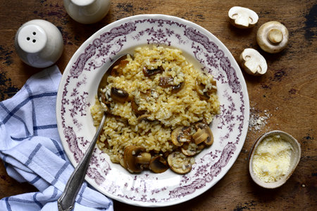 Risotto with mushrooms and cheese on a vintage plate over rustic wooden background. Top view with copy space.の写真素材