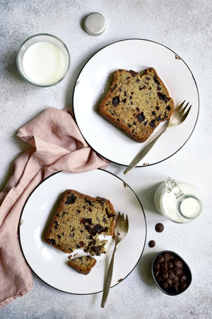 Homemade delicious cake with chocolate drops on a plates over white slate, stone or concrete background. Top view with copy space.の写真素材