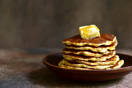 Homemade delicious pancakes with butter and maple syrup on a dark rustic background.の写真素材